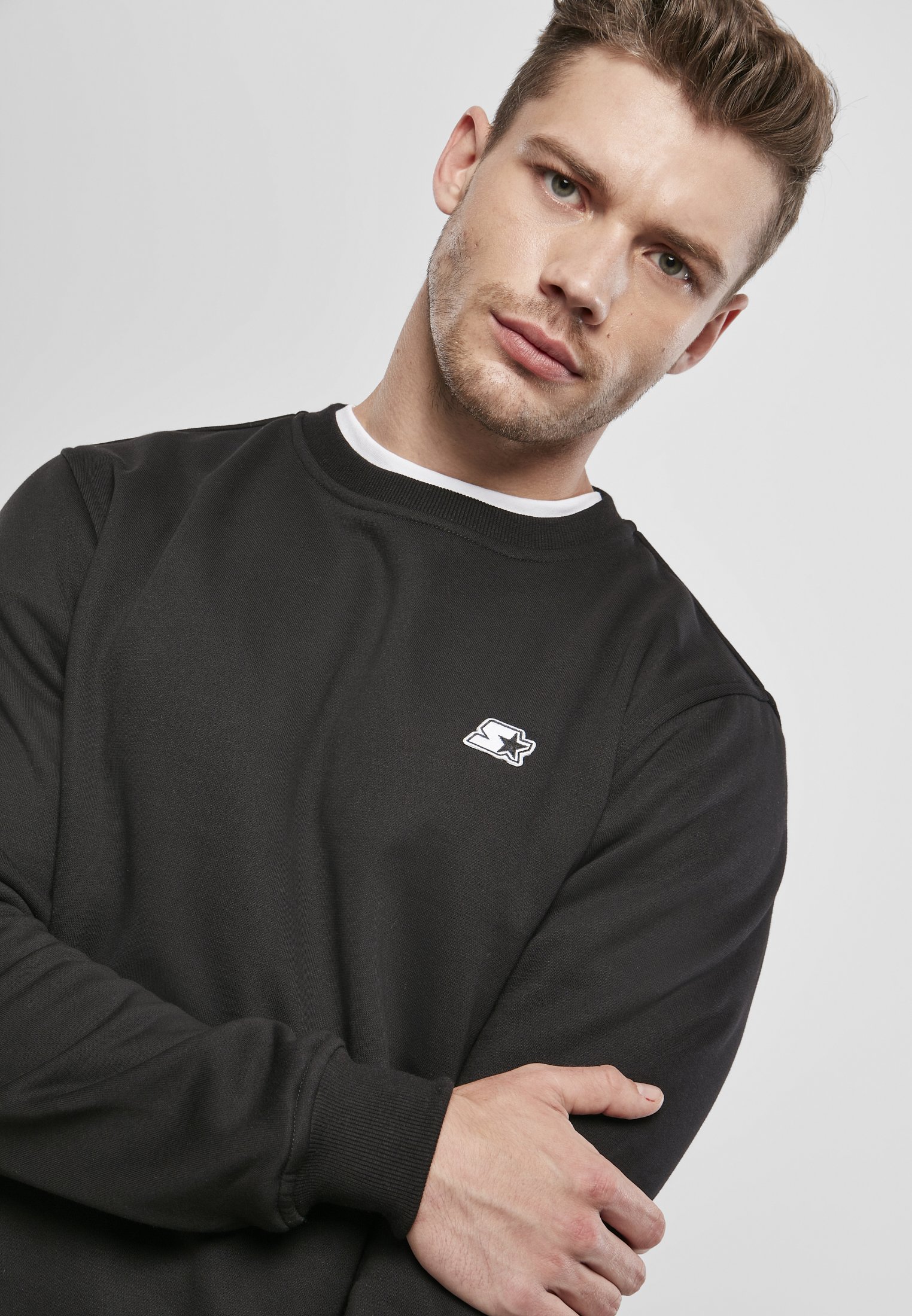 A cozy Starter Essential Crewneck Sweatshirt in various colors, showcasing its soft brushed fleece fabric and classic crewneck design.