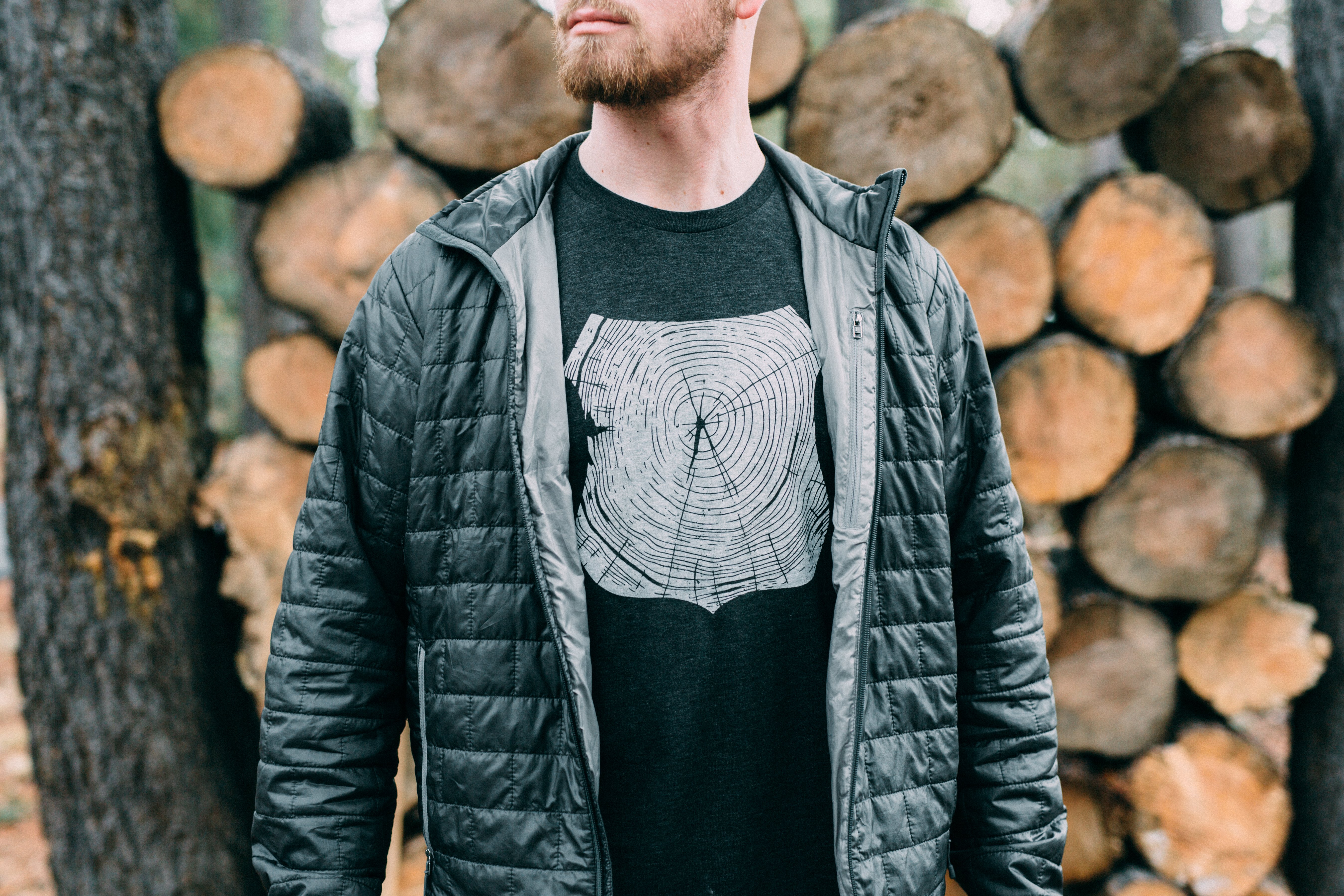 Charcoal Stump Tee featuring a hand-drawn forest design, made from a soft tri-blend fabric.