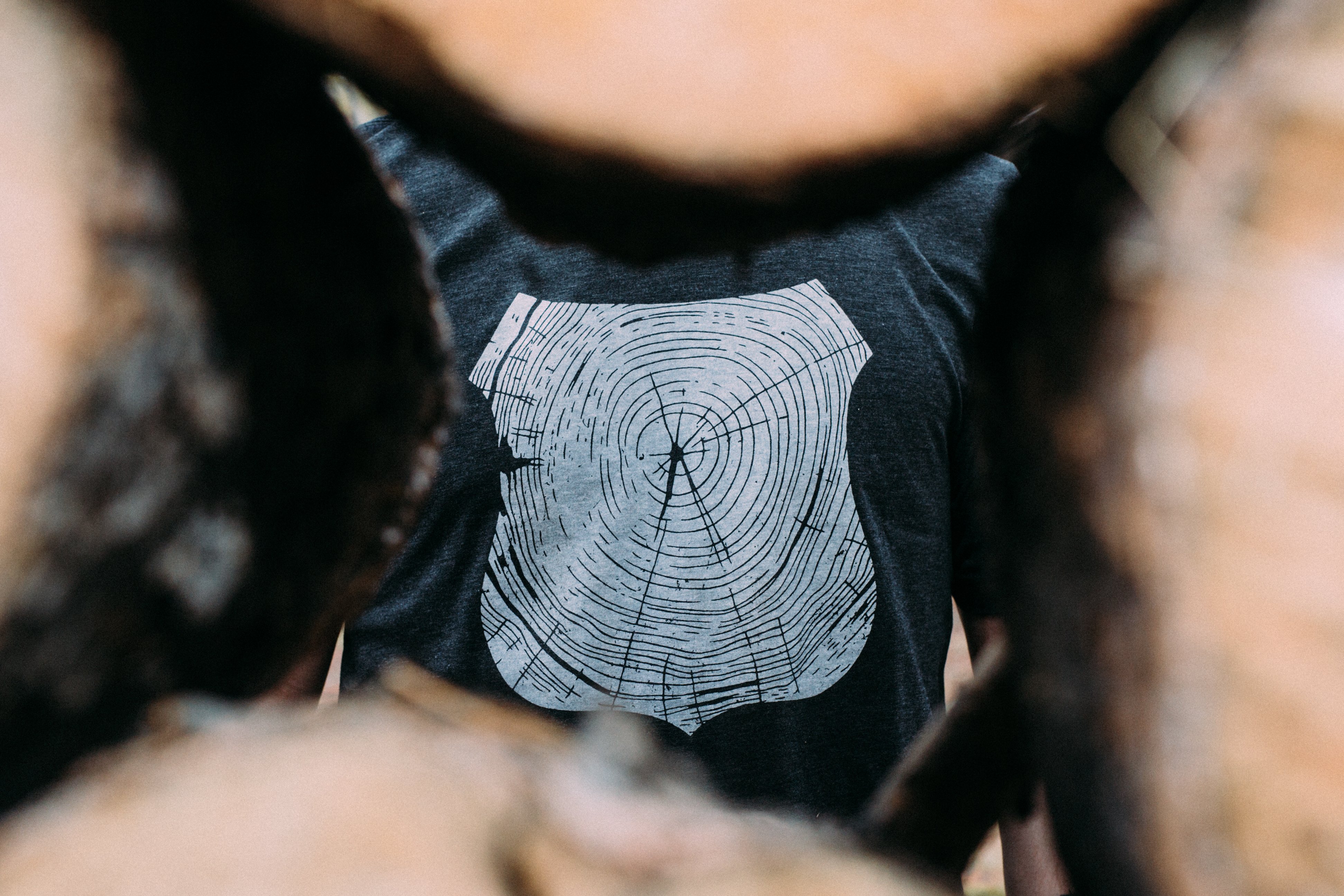 Charcoal Stump Tee featuring a hand-drawn forest design, made from a soft tri-blend fabric.