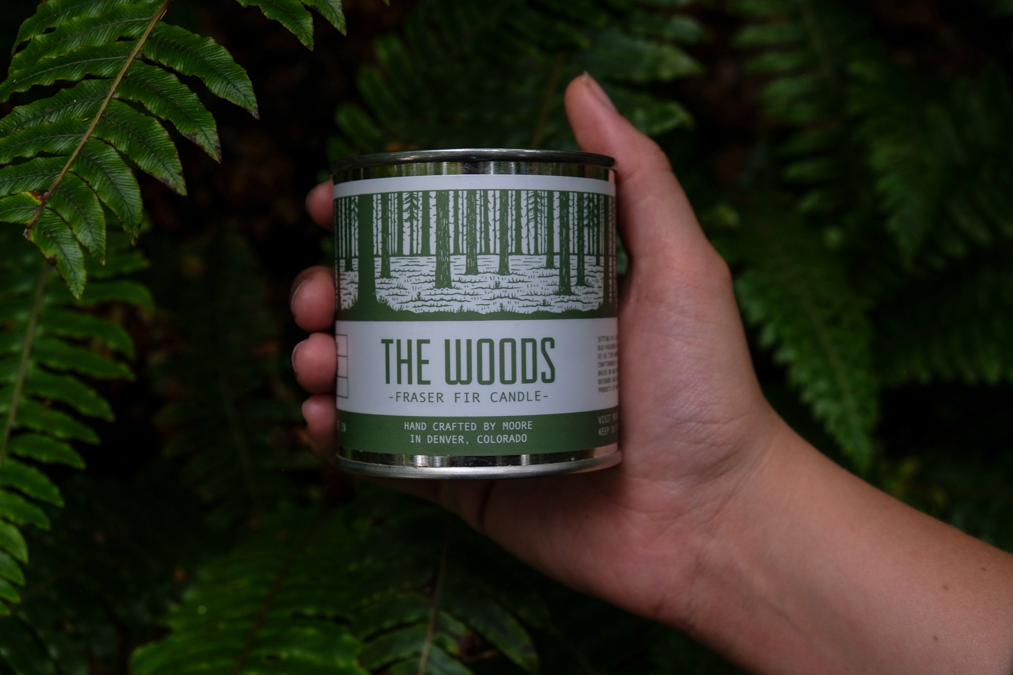 A beautifully handcrafted Woods Candle in a glass jar, showcasing its natural soy wax and elegant label inspired by the outdoors.