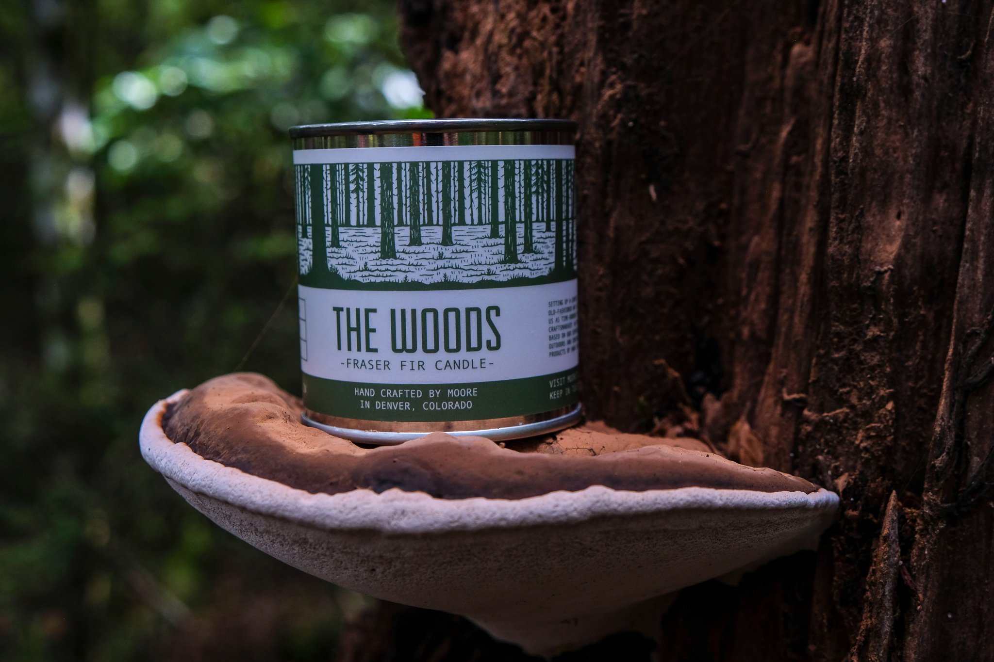 A beautifully handcrafted Woods Candle in a glass jar, showcasing its natural soy wax and elegant label inspired by the outdoors.