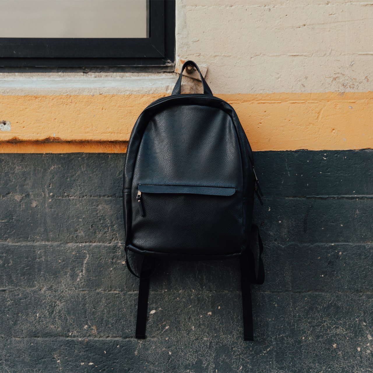 Tucker Vegan Leather Backpack featuring a sleek minimalist design, padded straps, and a soft laptop sleeve.