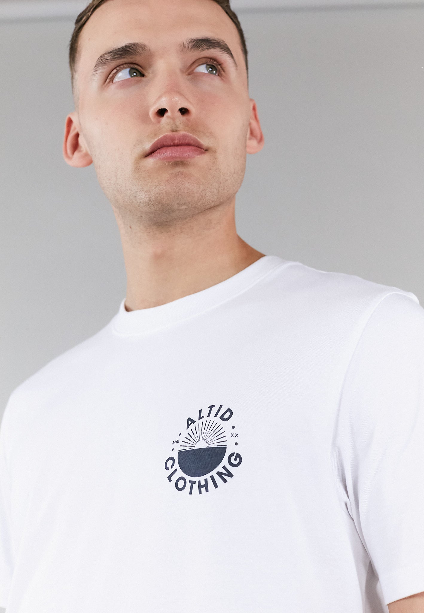 A stylish white graphic t-shirt made from 100% pure cotton, featuring a crew neck and an altid printed logo, perfect for versatile wear.