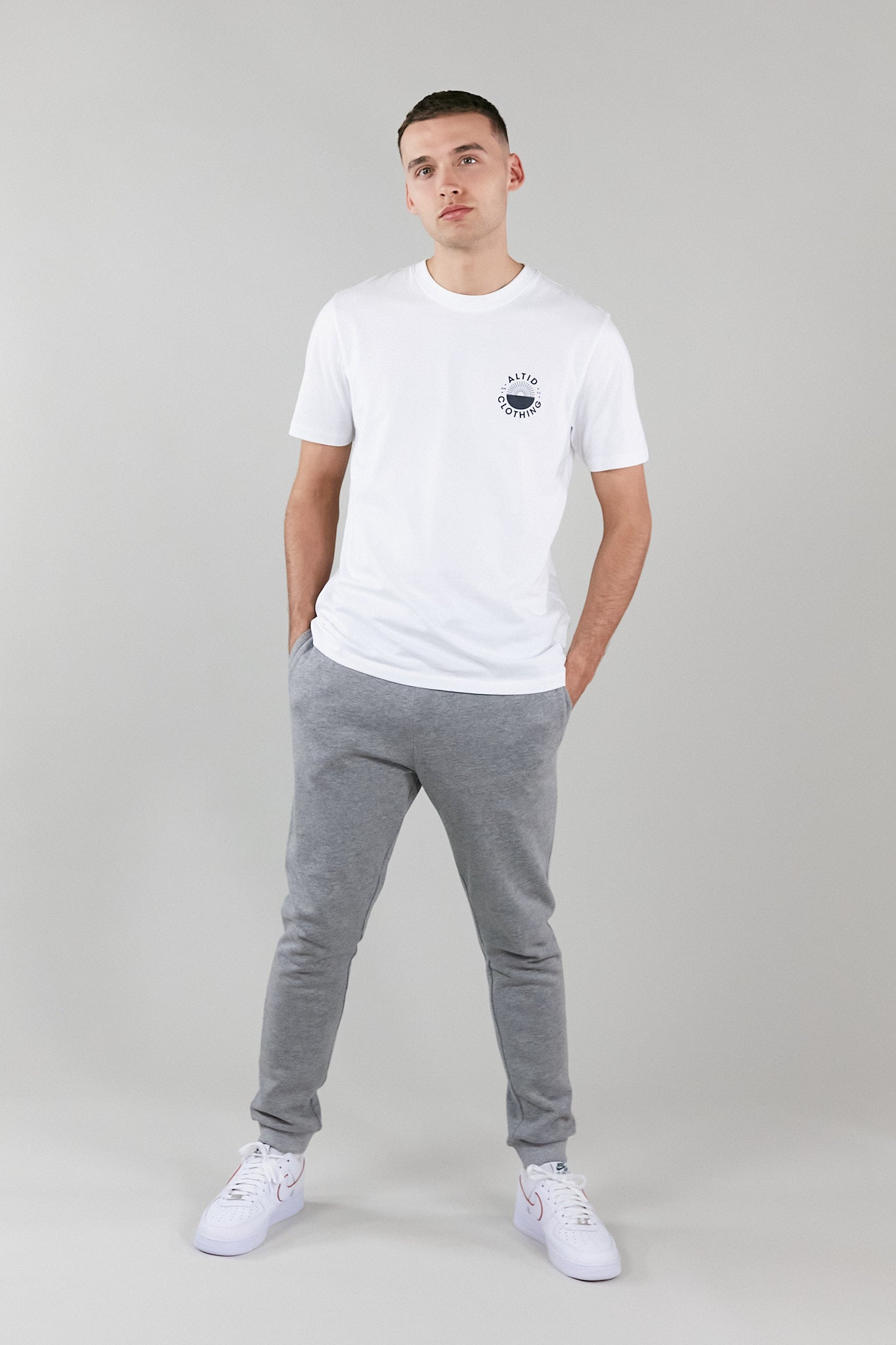 A stylish white graphic t-shirt made from 100% pure cotton, featuring a crew neck and an altid printed logo, perfect for versatile wear.