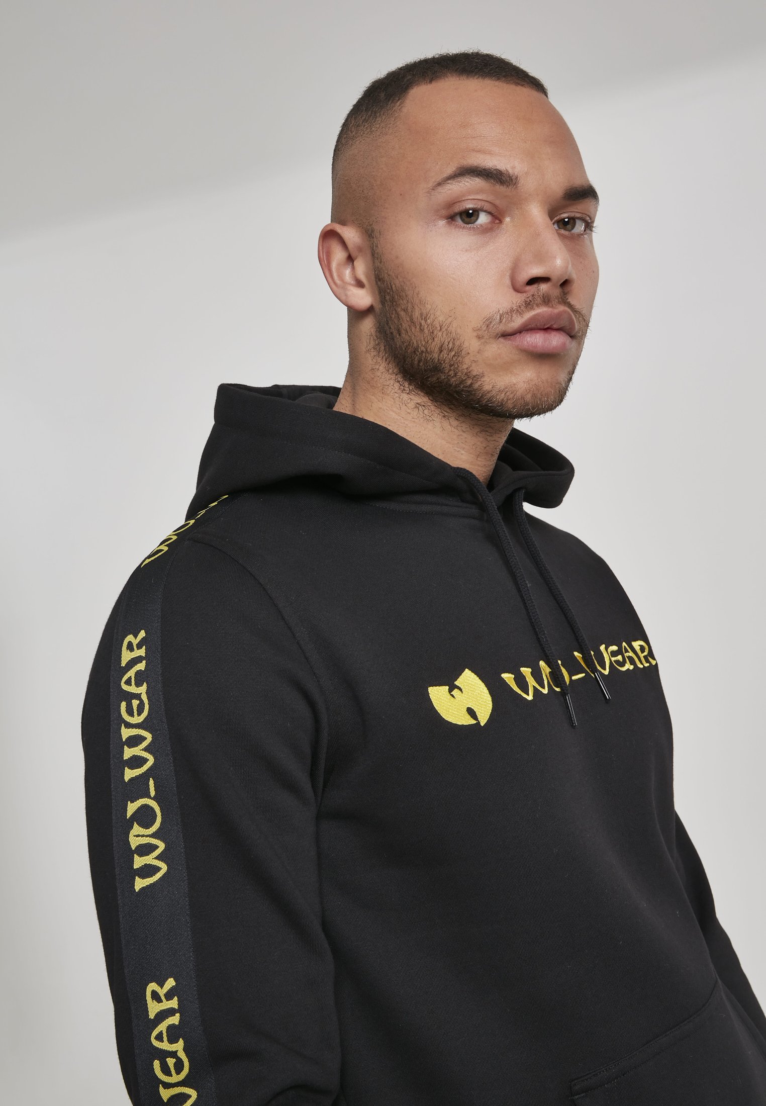 Wu-Wear Tape Hoodie featuring unique sidetape and front embroidery, crafted from soft half brushed fleece fabric.