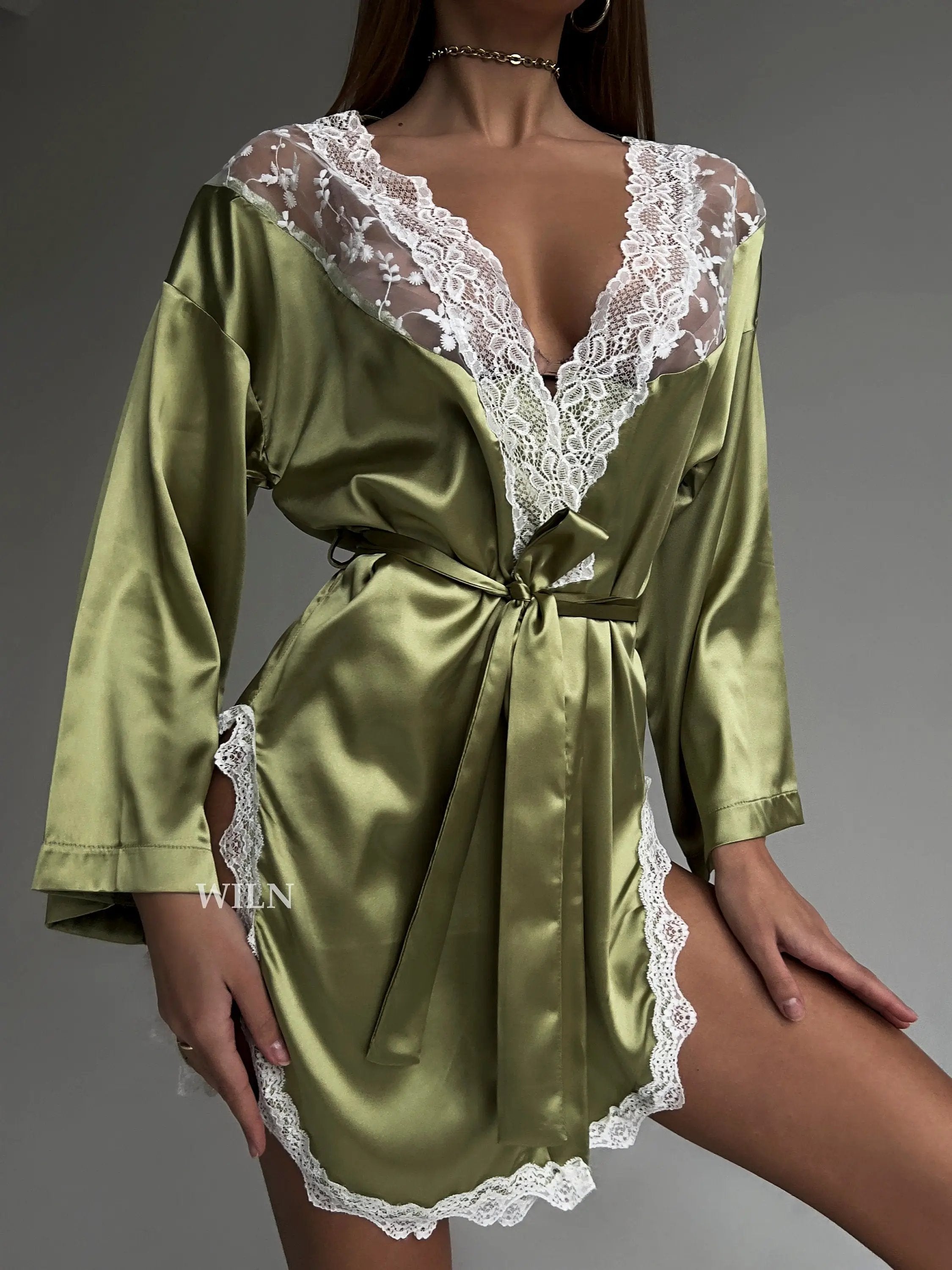 A luxurious green satin robe with flowy long sleeves and lace trim, perfect for brides and special occasions.