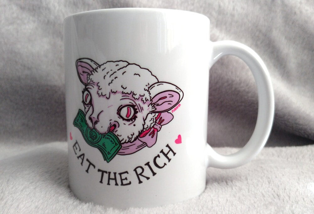 Ceramic mug with the phrase 'Eat The Rich' printed in bold, featuring a high-quality design and durable finish.