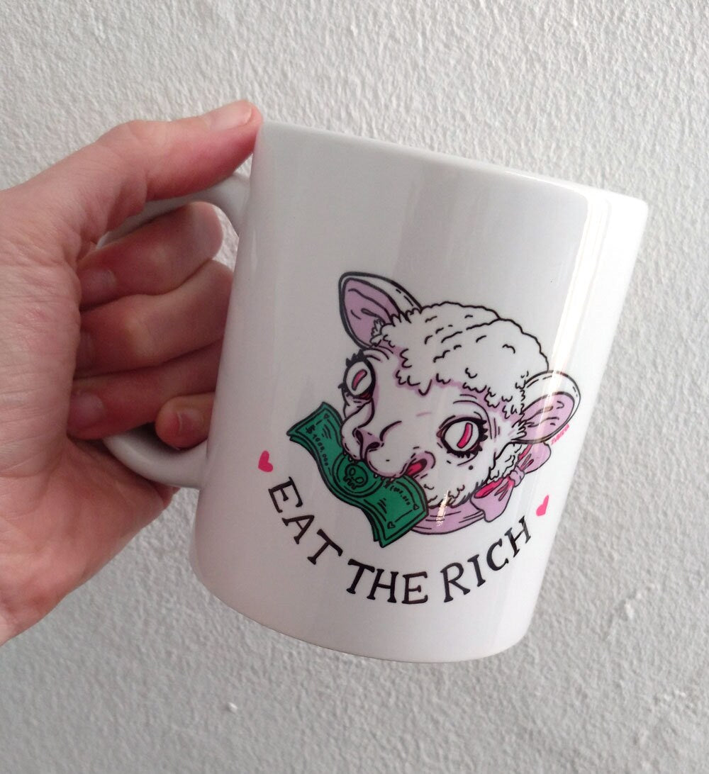 Ceramic mug with the phrase 'Eat The Rich' printed in bold, featuring a high-quality design and durable finish.