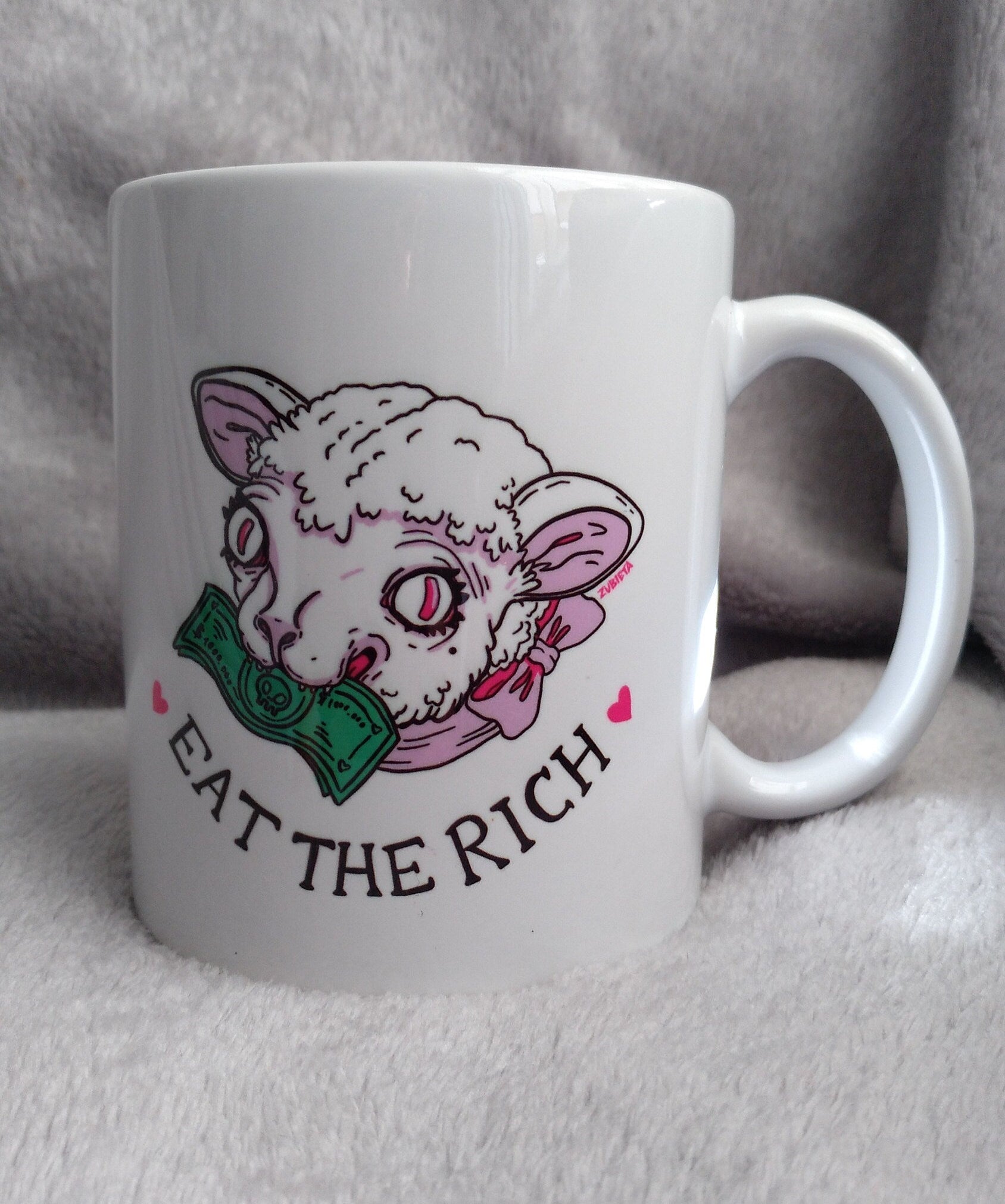 Ceramic mug with the phrase 'Eat The Rich' printed in bold, featuring a high-quality design and durable finish.