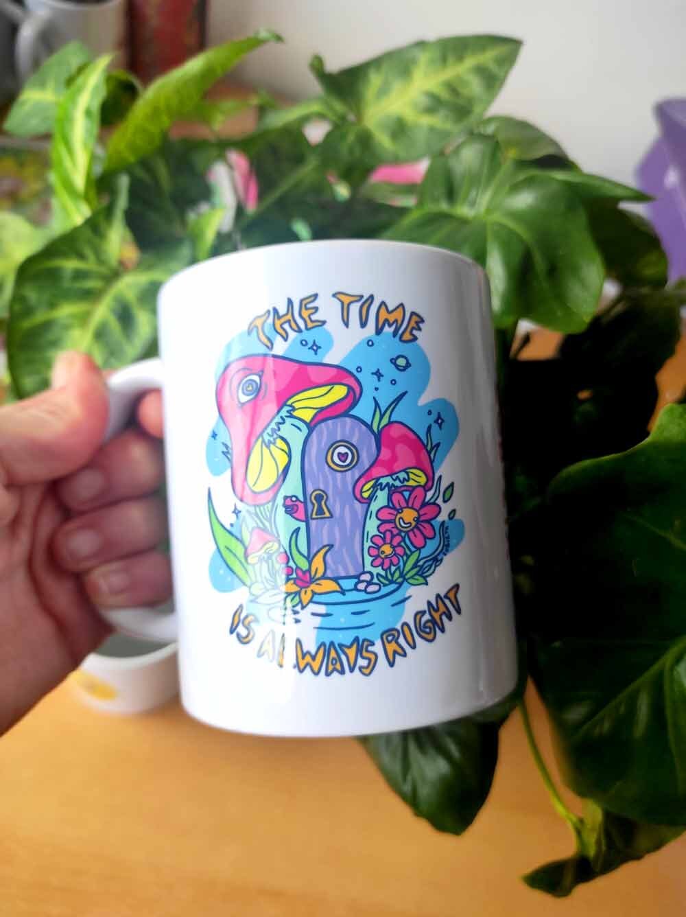 Ceramic mug with colorful design 'The Time Is Always Right', showcasing its vibrant print and sturdy handle.