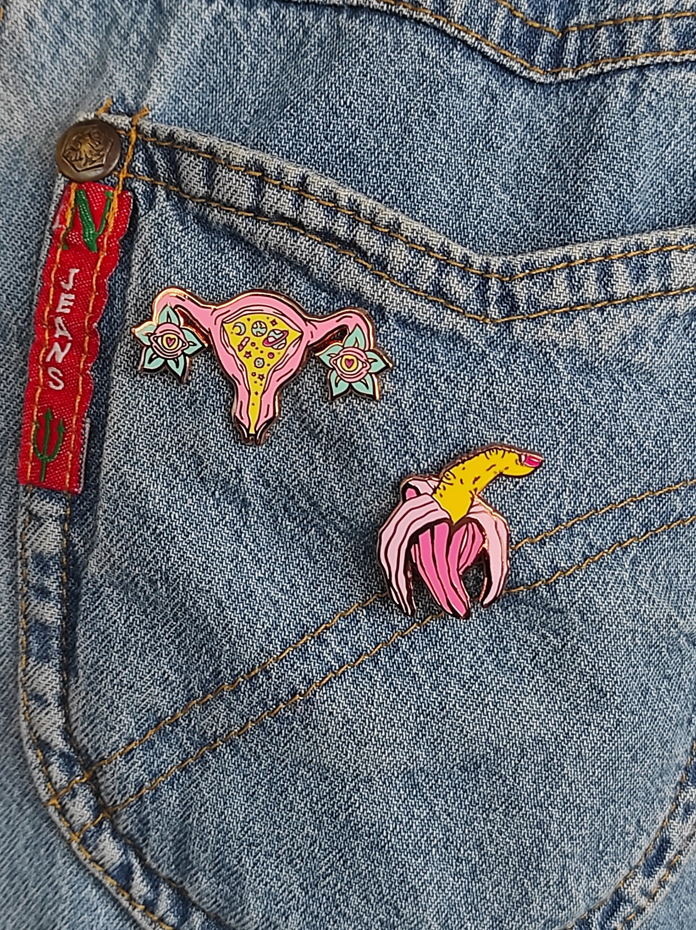 Cosmic uterus enamel pin with rose gold finish, featuring a psychedelic design that celebrates femininity and body positivity.