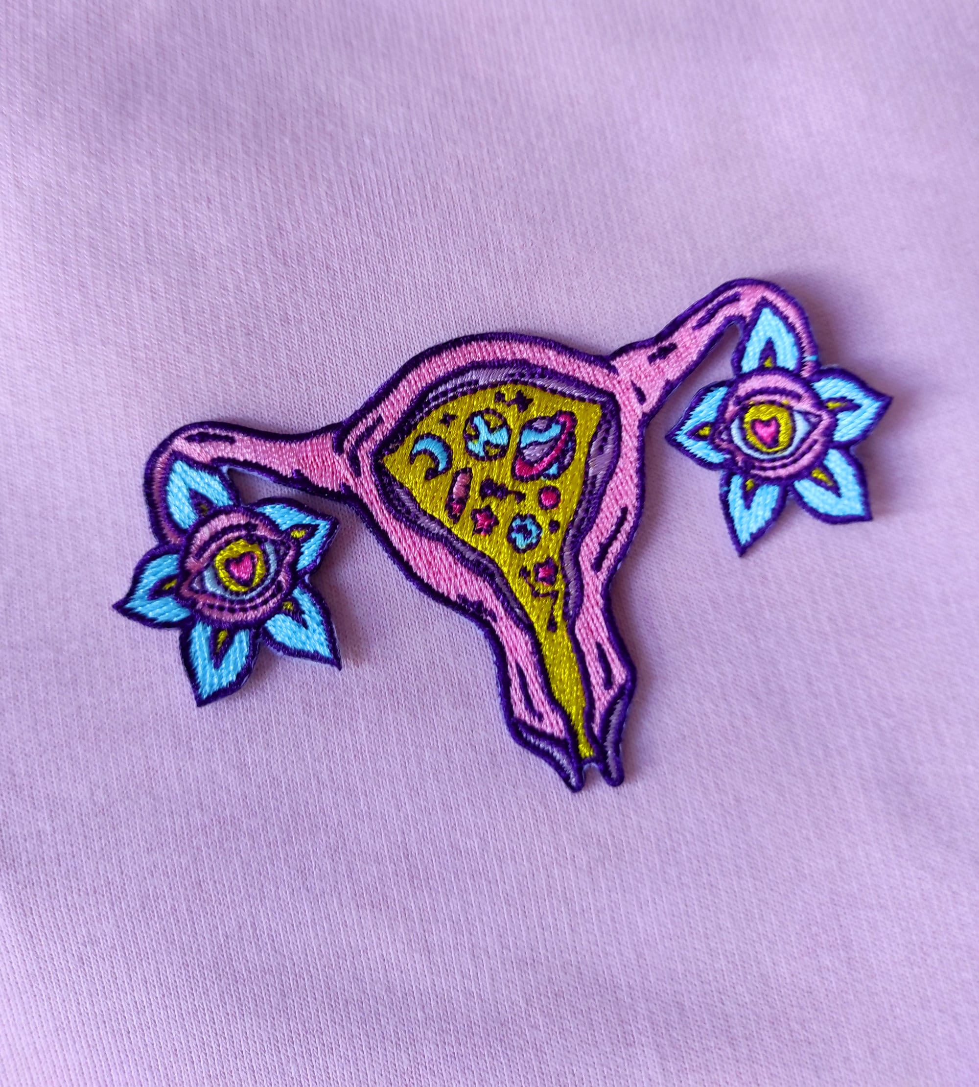 Cosmic Uterus Patch featuring a psychedelic embroidered design in six vibrant colors, measuring 12.5cm x 12.5cm.