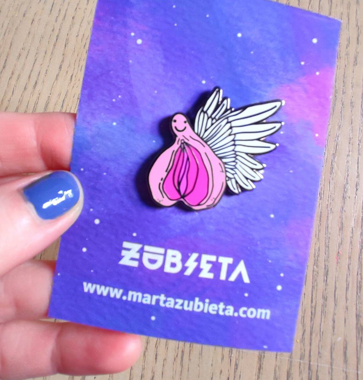 A colorful enamel pin featuring a whimsical design of flying vaginas in space, symbolizing body positivity and empowerment.