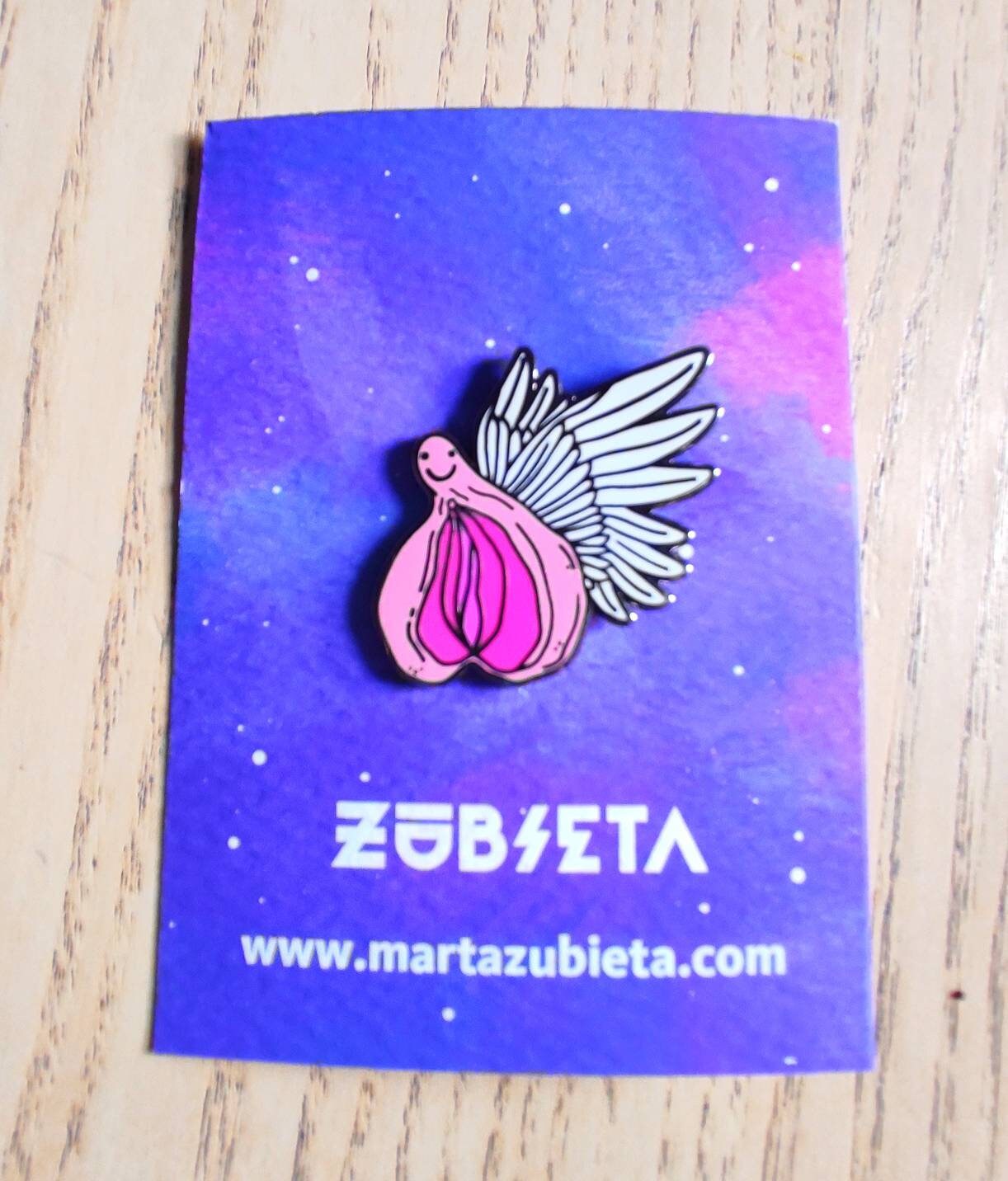 A colorful enamel pin featuring a whimsical design of flying vaginas in space, symbolizing body positivity and empowerment.