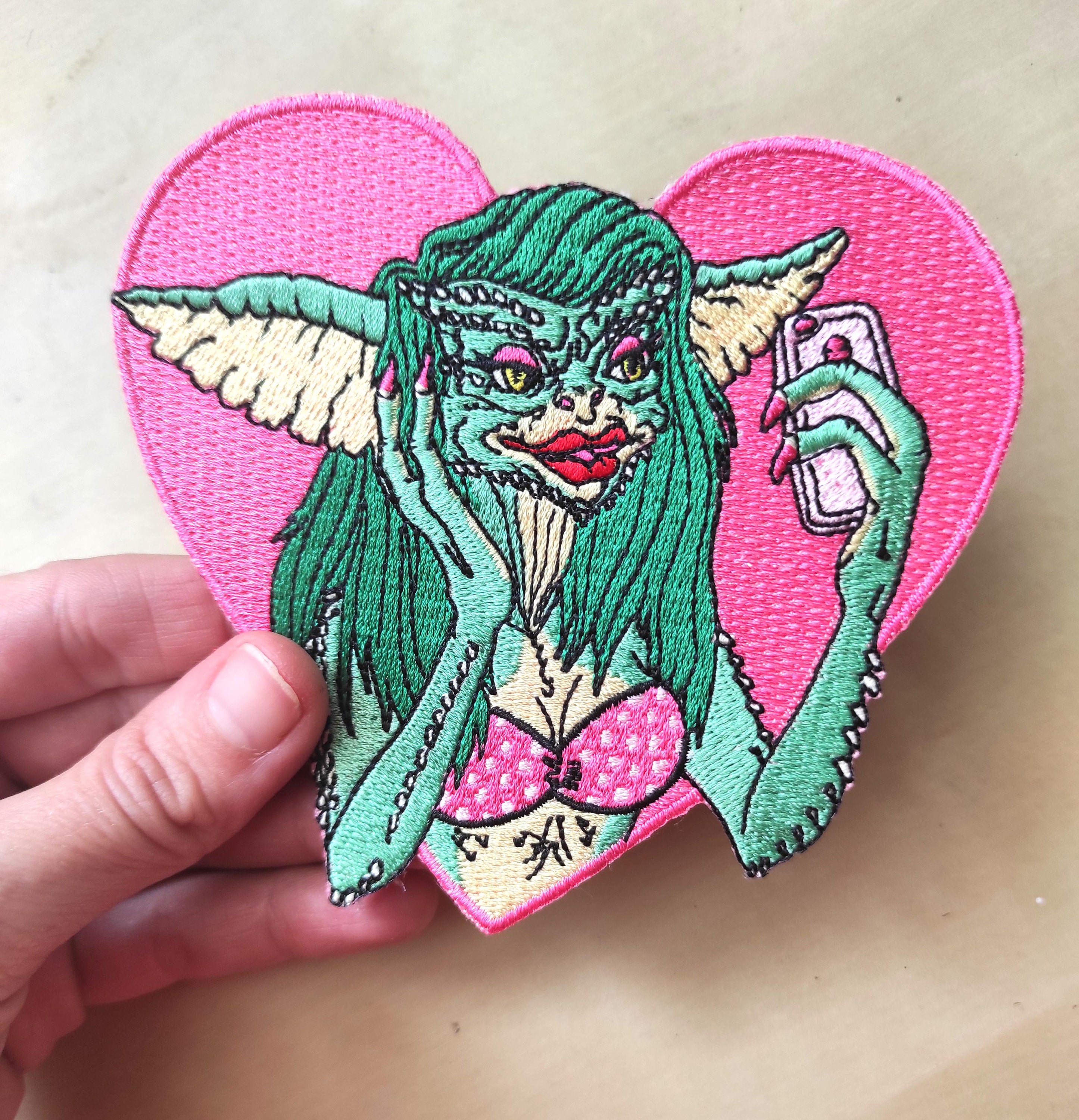 Greta The Gremlin Embroidered Patch featuring vibrant colors and playful design, measuring 12.5cm x 12.5cm.