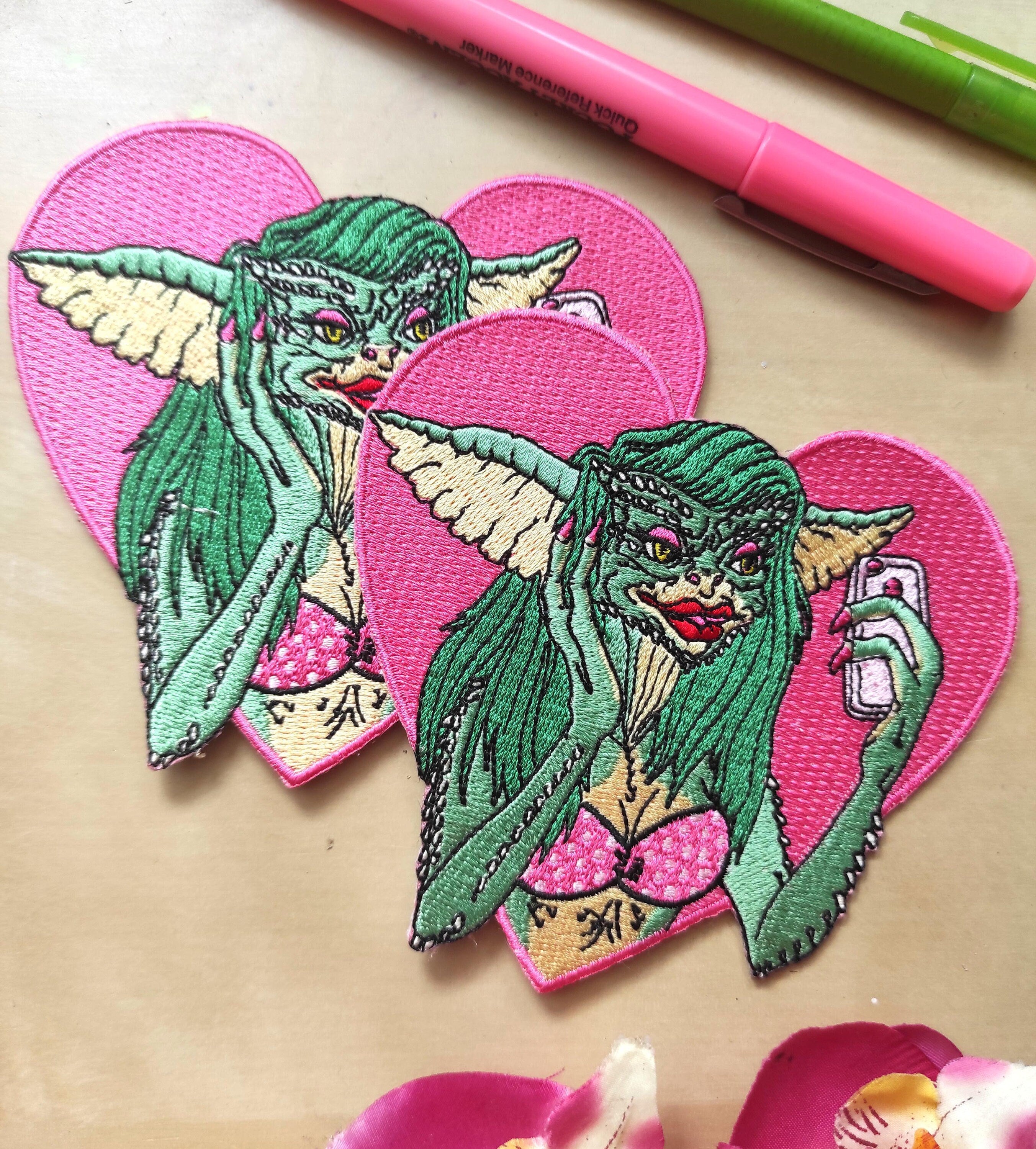 Greta The Gremlin Embroidered Patch featuring vibrant colors and playful design, measuring 12.5cm x 12.5cm.