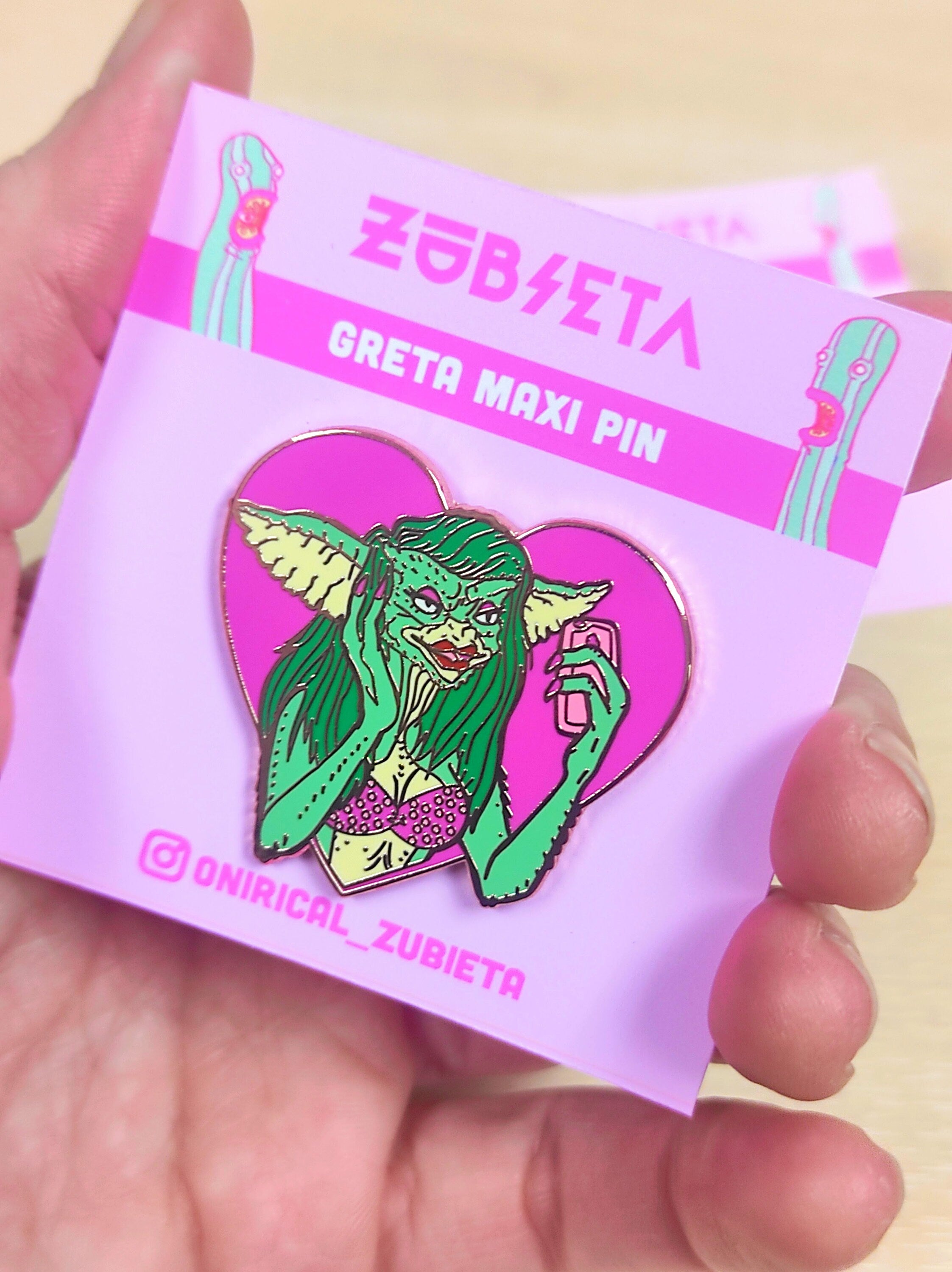 Greta the Gremlin Maxi Pin featuring a cute and creepy design, 2 inches wide, made of hard enamel with a rose gold metal finish.