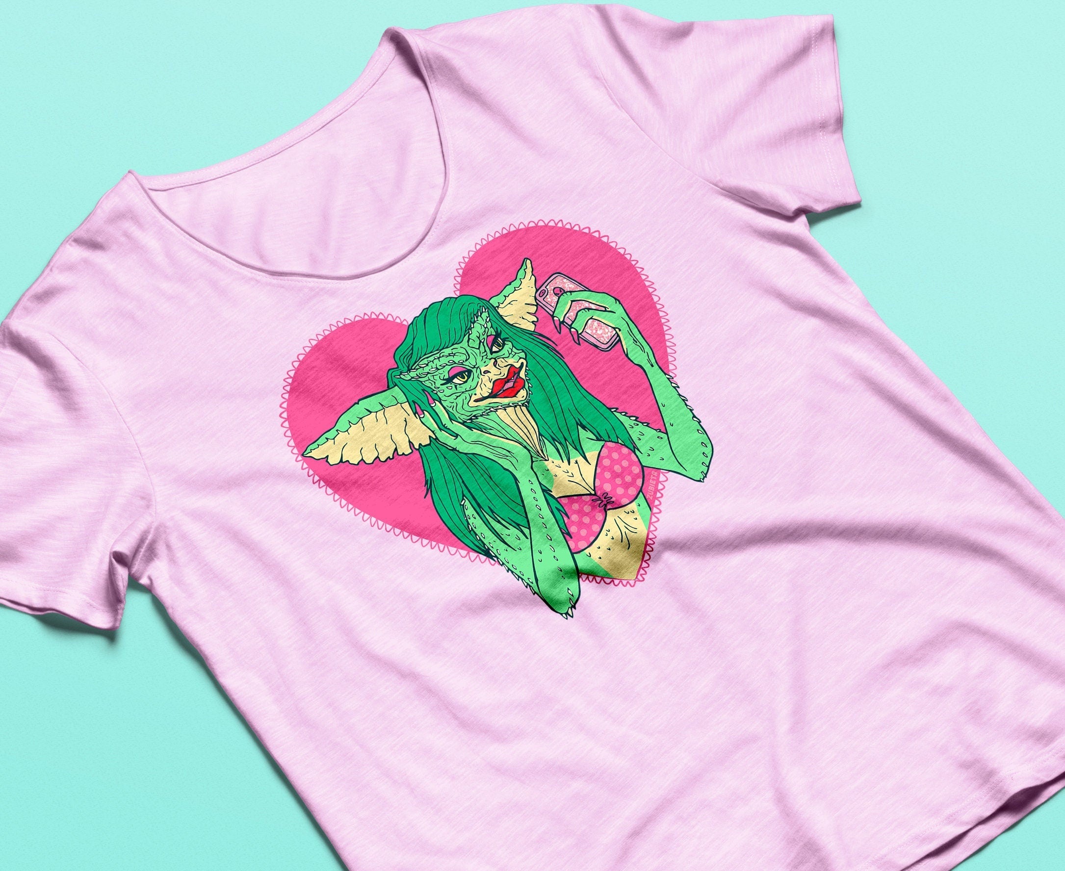 Greta the Gremlin pink organic cotton t-shirt featuring a vibrant print of the character Greta from The Gremlins movie.