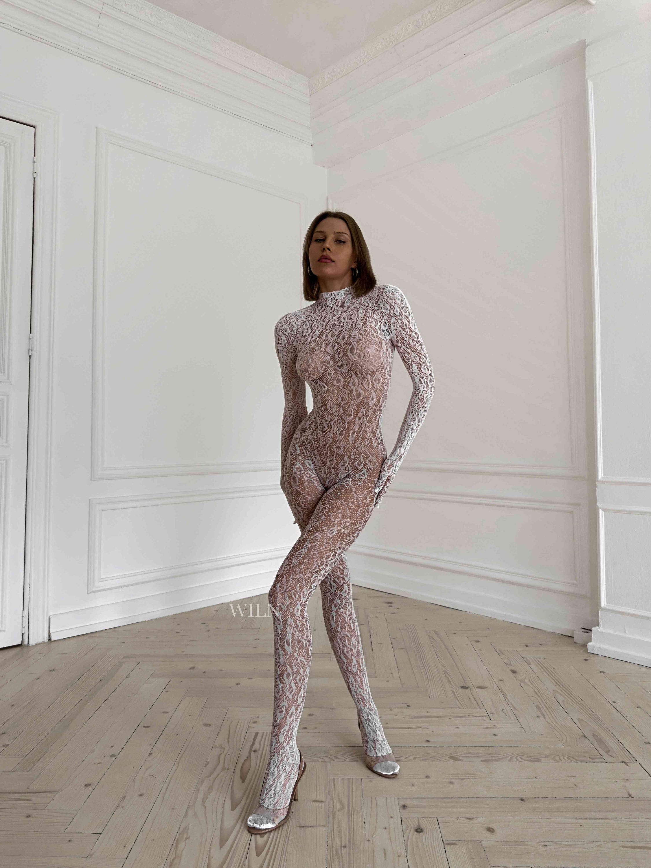 LIBIDO WHITE Bodysuit featuring a flattering fishnet design, available in multiple colors, elegantly displayed on a mannequin.