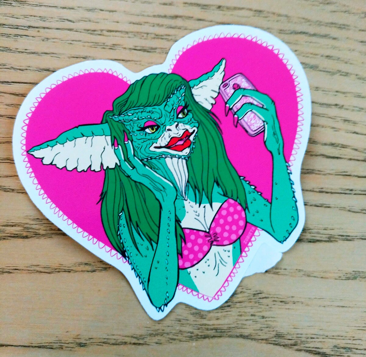 A pack of two colorful vinyl stickers featuring Greta the Gremlin and the phrase Monsters Need Love Too, perfect for 80's horror movie fans.