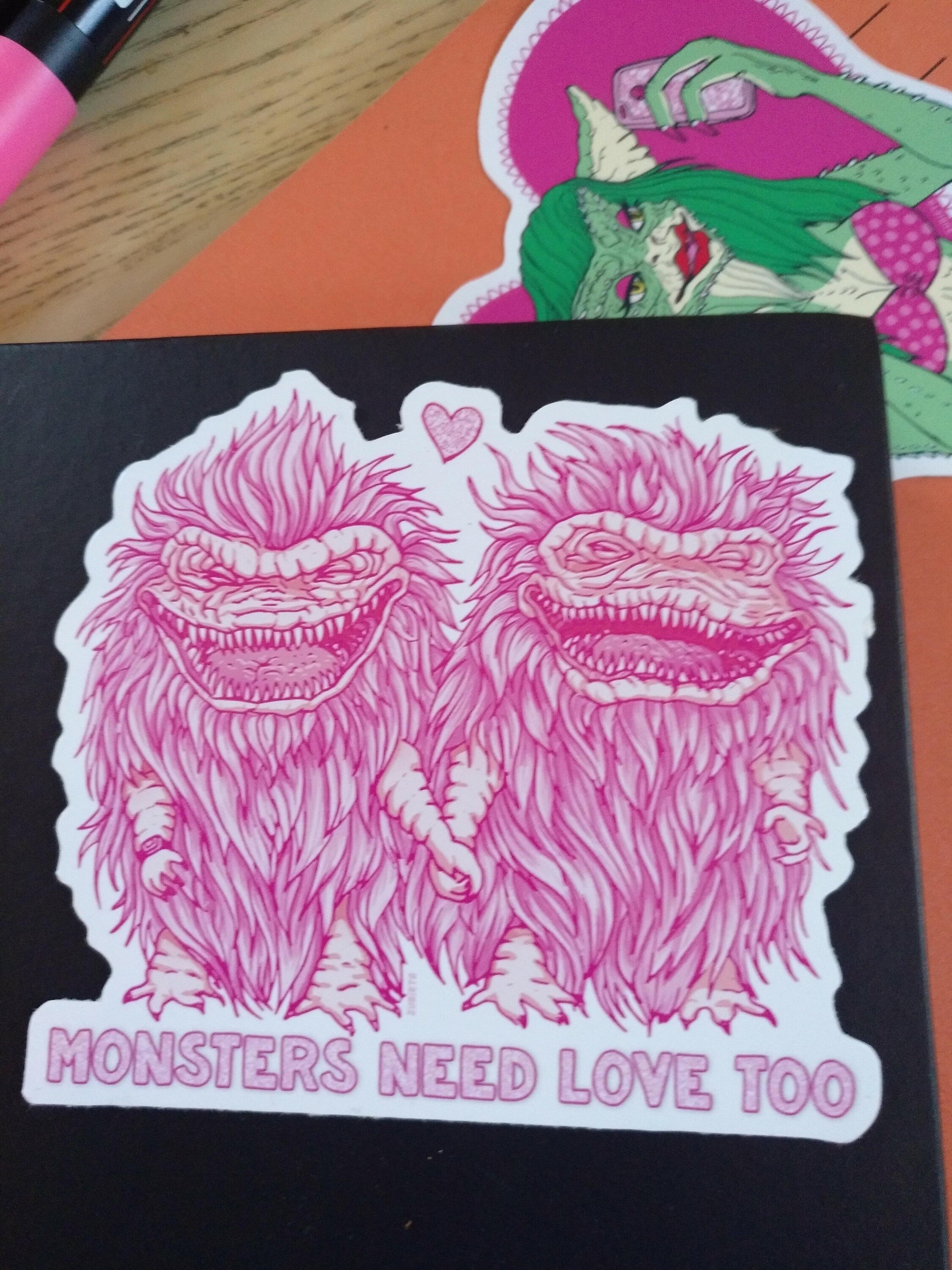 A pack of two colorful vinyl stickers featuring Greta the Gremlin and the phrase Monsters Need Love Too, perfect for 80's horror movie fans.