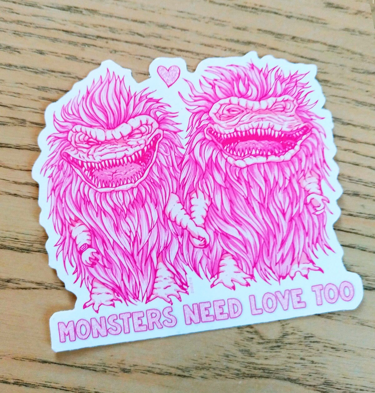 A pack of two colorful vinyl stickers featuring Greta the Gremlin and the phrase Monsters Need Love Too, perfect for 80's horror movie fans.