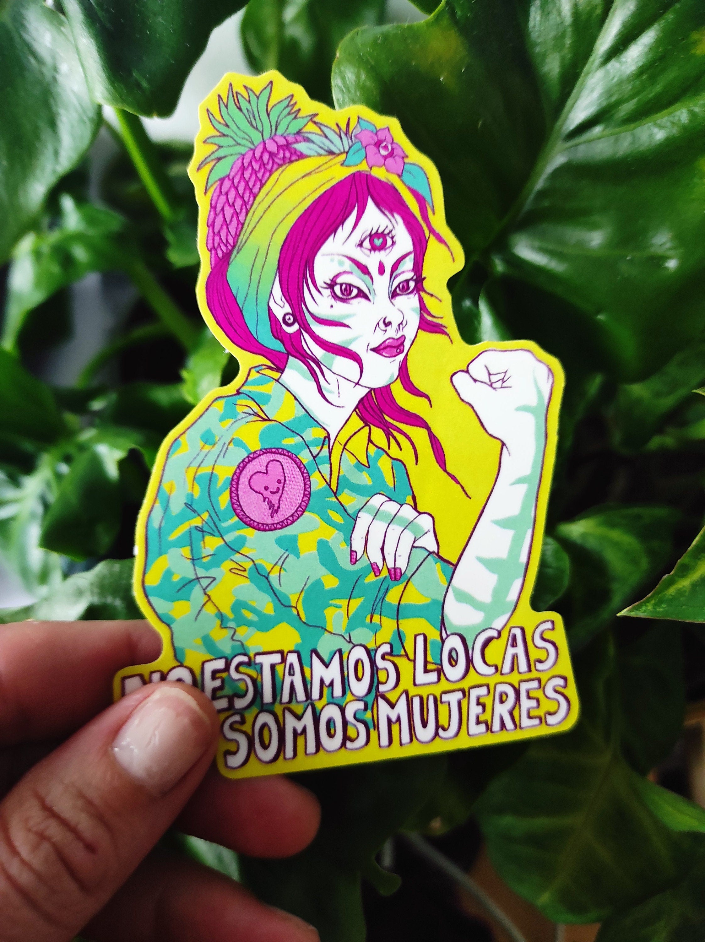 A vibrant Rosie The Riveter sticker featuring the phrase 'No estamos locas! Somos Mujeres!' celebrating women's empowerment.