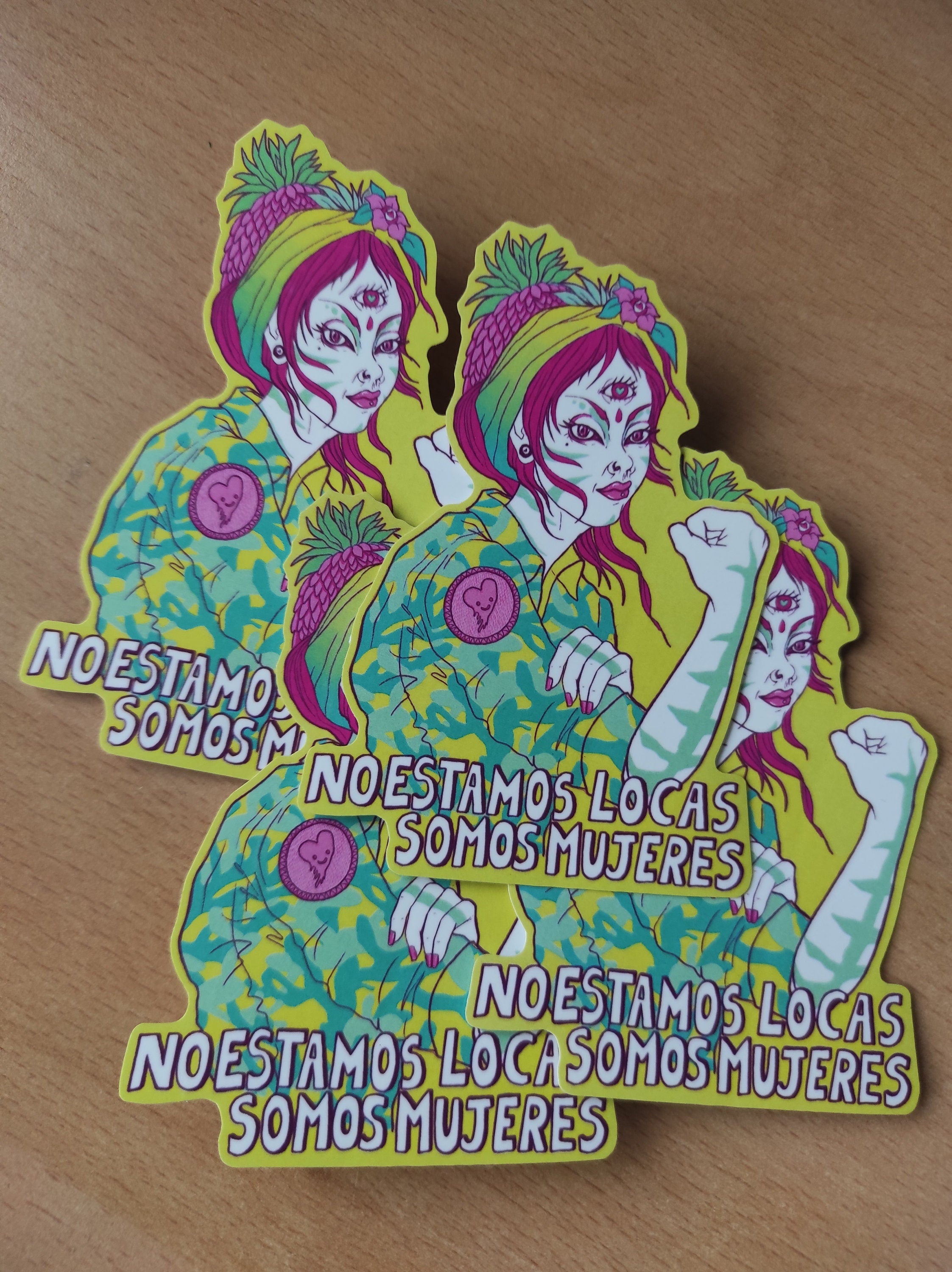 A vibrant Rosie The Riveter sticker featuring the phrase 'No estamos locas! Somos Mujeres!' celebrating women's empowerment.