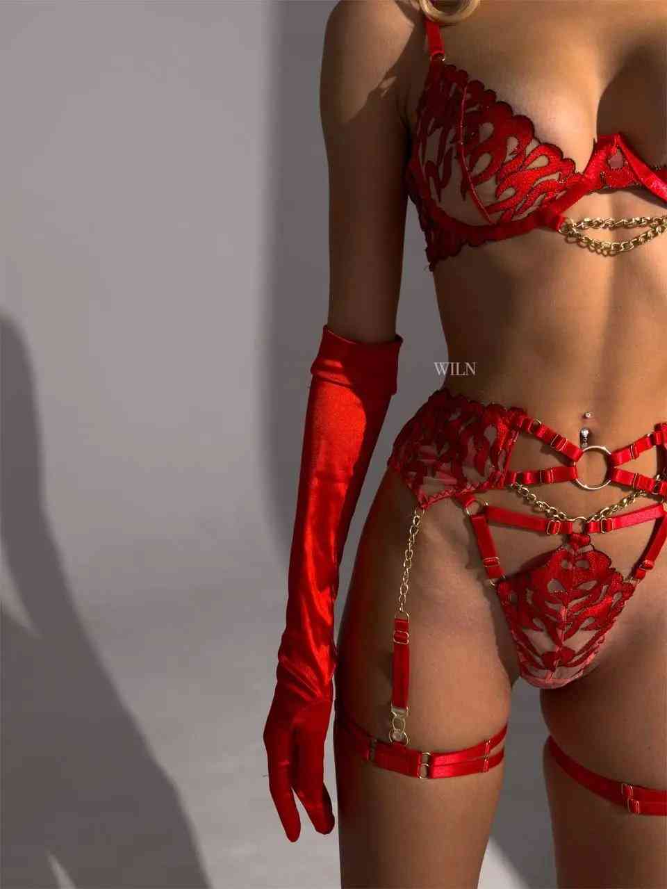 A stunning red 3-piece lingerie set featuring a bra, panties, and garter belt with gold chain accents and flame mesh pattern.