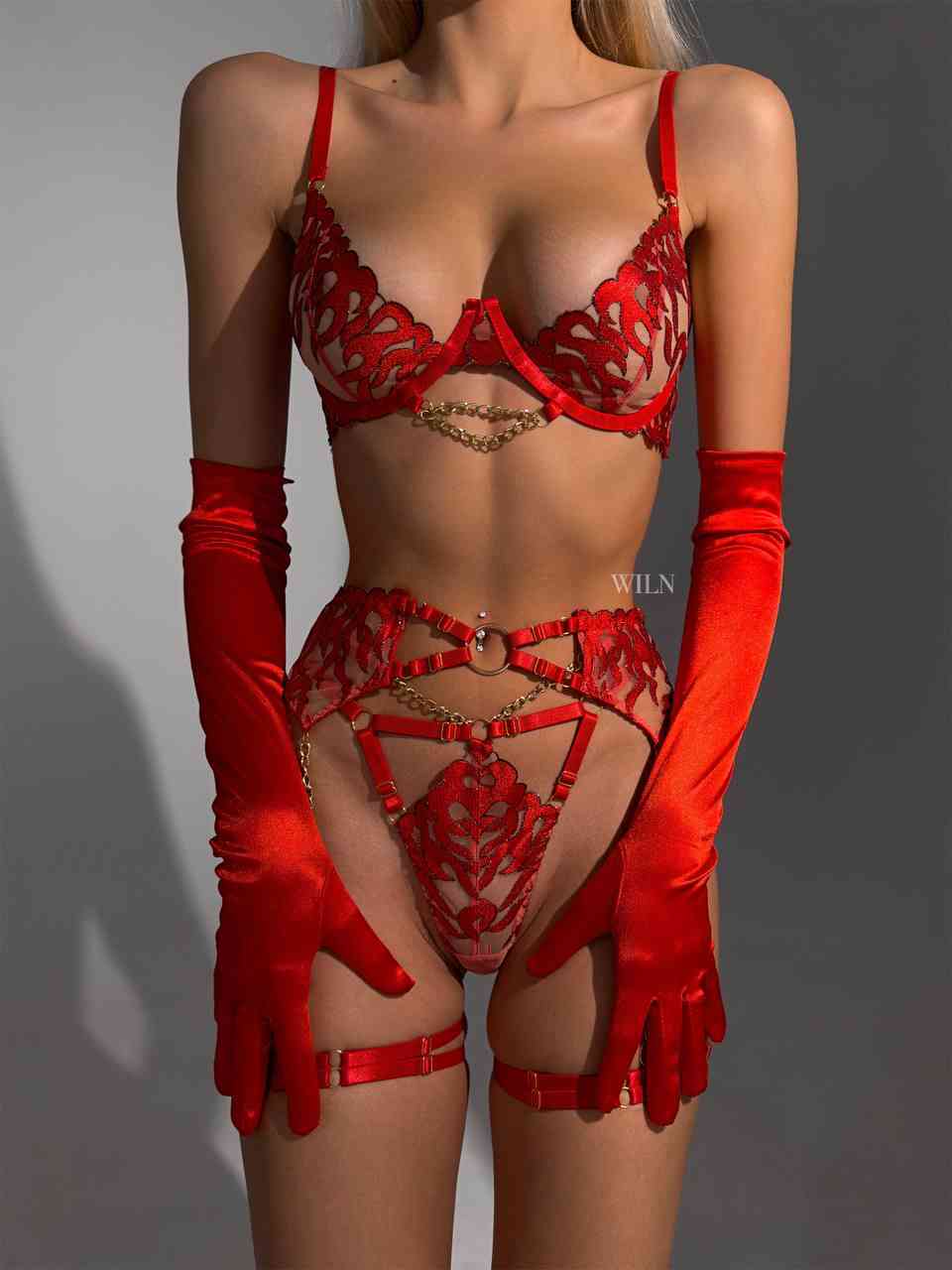 A stunning red 3-piece lingerie set featuring a bra, panties, and garter belt with gold chain accents and flame mesh pattern.