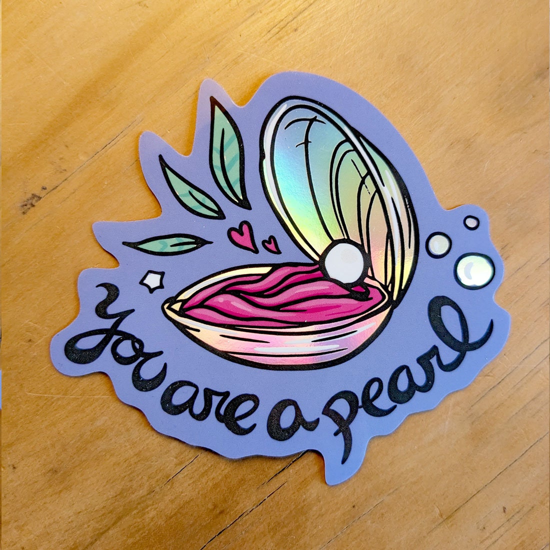 You Are a Pearl Holographic Vinyl Sticker featuring an oyster shell design with a shimmering holographic finish.