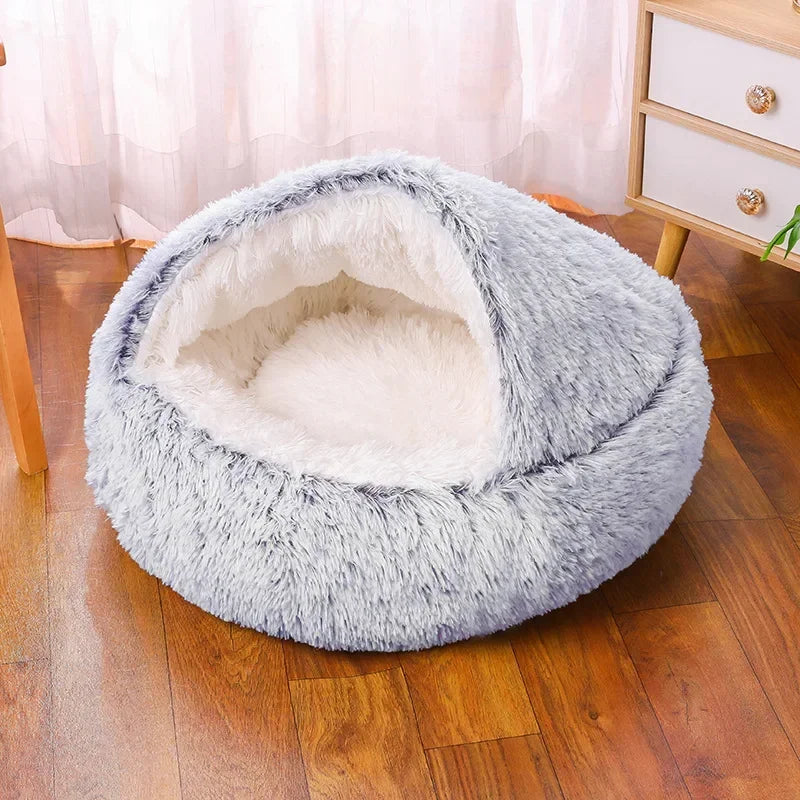 A cozy Plush Round Cat Bed in gray, brown, and pink colors, designed for comfort with a soft plush material, perfect for cats to relax and sleep.