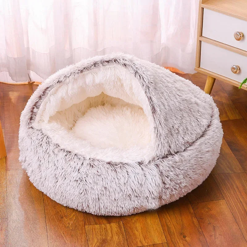 A cozy Plush Round Cat Bed in gray, brown, and pink colors, designed for comfort with a soft plush material, perfect for cats to relax and sleep.