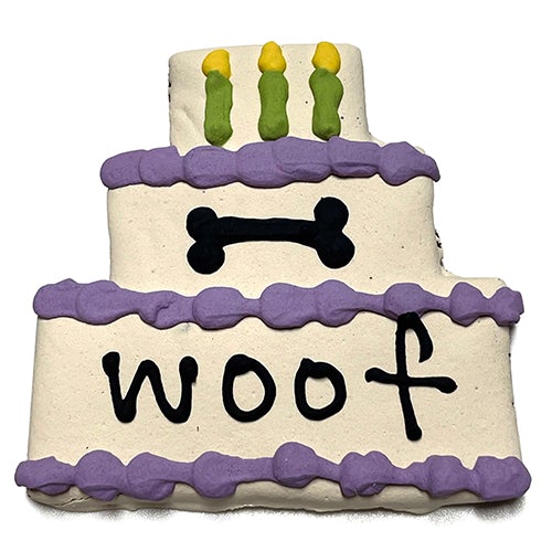 A colorful assortment of Cake Treats for dogs, featuring a large birthday cake design, topped with yogurt coating and vibrant vegetable coloring.