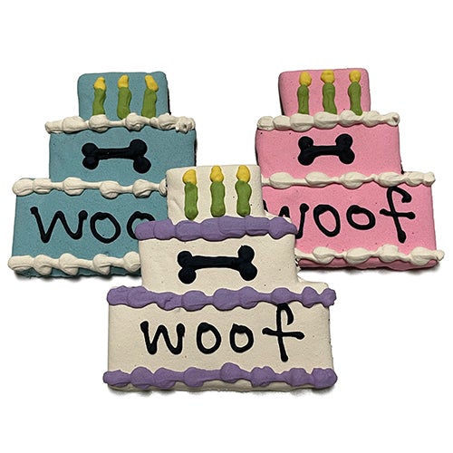 A colorful assortment of Cake Treats for dogs, featuring a large birthday cake design, topped with yogurt coating and vibrant vegetable coloring.