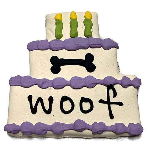 A colorful assortment of Cake Treats for dogs, featuring a large birthday cake design, topped with yogurt coating and vibrant vegetable coloring.