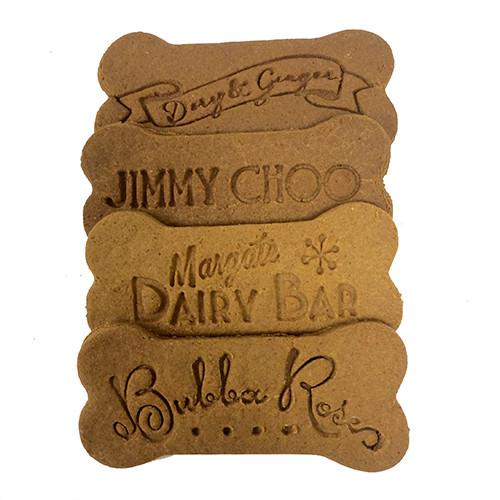 Custom logo bones shaped dog treats featuring a personalized logo or dog's name, available in peanut butter, bacon, and cheese flavors.