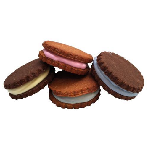 A box of colorful French-inspired macarons filled with yogurt coating, showcasing peanut butter and carob flavors.