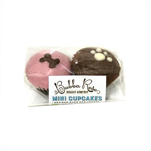 A box containing two mini cupcakes for dogs, made with peanut butter and apple cake, featuring a yogurt coating and colorful vegetable coloring.