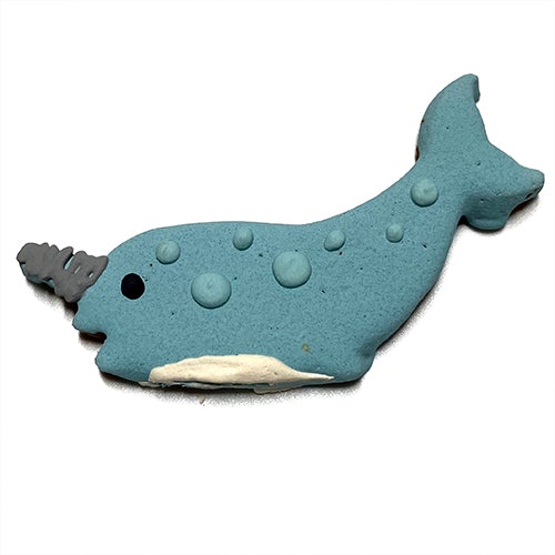 A whimsical narwhal-shaped dog treat made from peanut butter, oat flour, and honey, topped with yogurt coating.