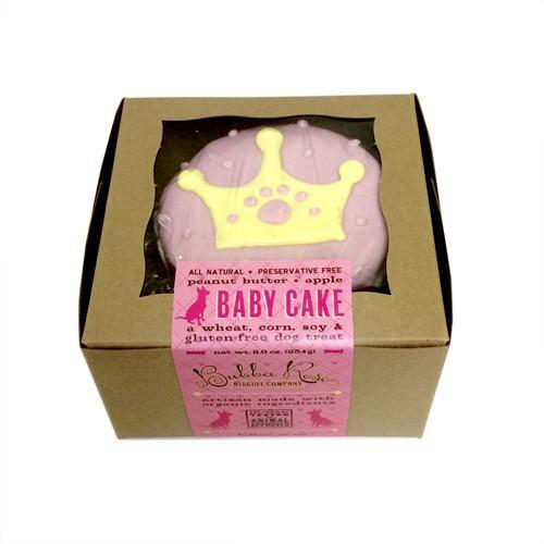 Princess Baby Cake for dogs, a peanut butter apple flavored treat, displayed in a box, showcasing its chewy texture and dark edges.