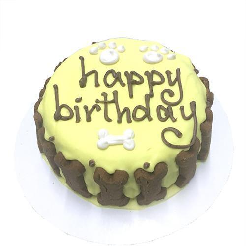 A beautifully decorated Yellow Dog Cake featuring a soft peanut butter banana base with a hard yogurt coating, perfect for medium to large dogs.