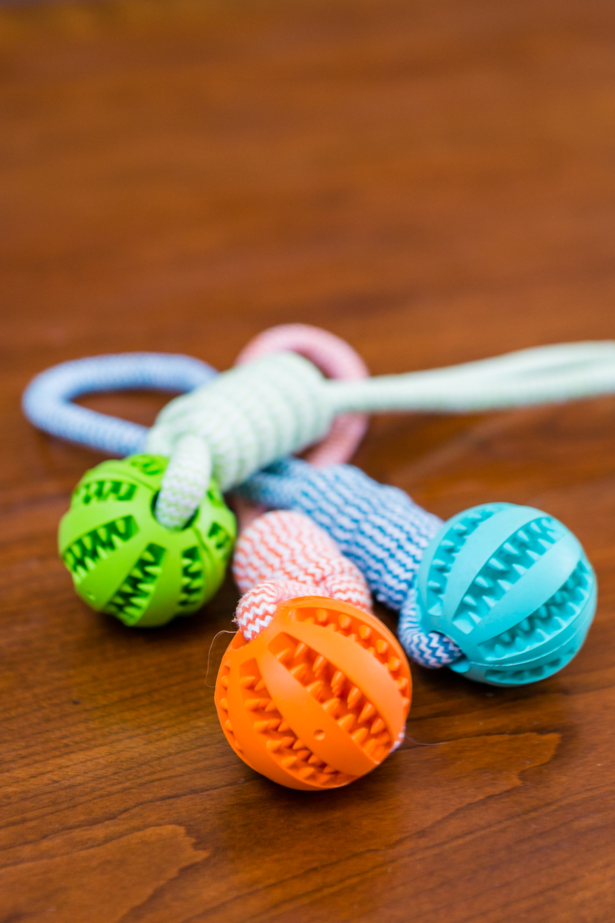 Durable rubber ball chew toy with cotton rope, designed for dogs, featuring a soft texture and vibrant colors for safe chewing and interactive play.