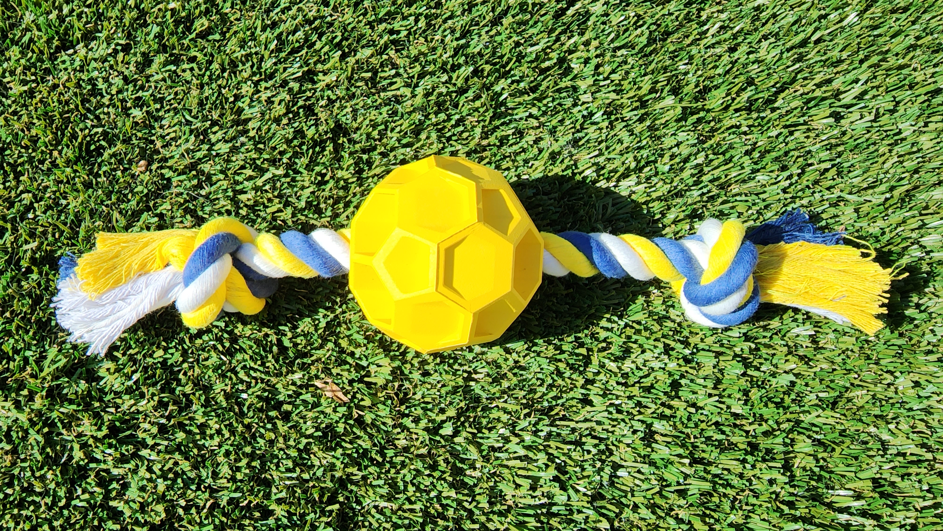 A durable rubber soccer ball chew toy with a sturdy tug rope, designed for active dogs of all sizes, promoting play and dental health.