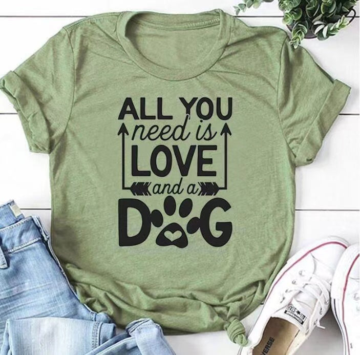 A soft unisex crewneck tee featuring the phrase 'All You Need Is Love And A Dog', perfect for dog lovers and fur mamas.