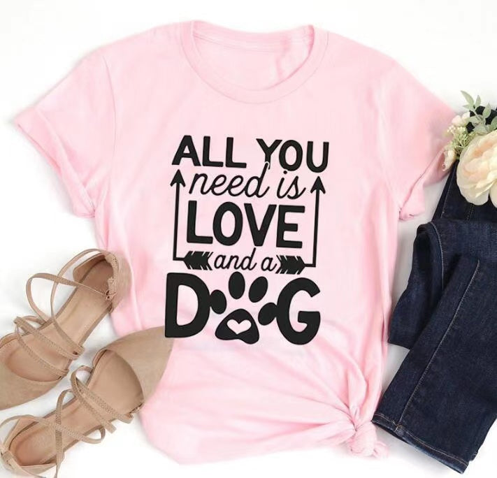 A soft unisex crewneck tee featuring the phrase 'All You Need Is Love And A Dog', perfect for dog lovers and fur mamas.