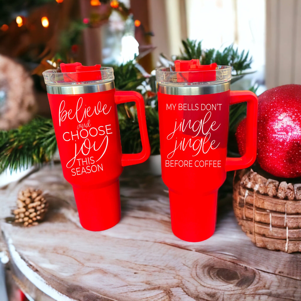 Believe + Joy 40oz insulated mug with a cheerful design and inspirational quote, featuring a lid, straw, and handle.