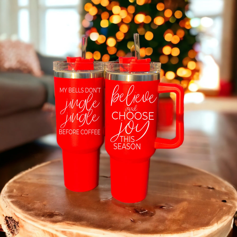 Believe + Joy 40oz insulated mug with a cheerful design and inspirational quote, featuring a lid, straw, and handle.