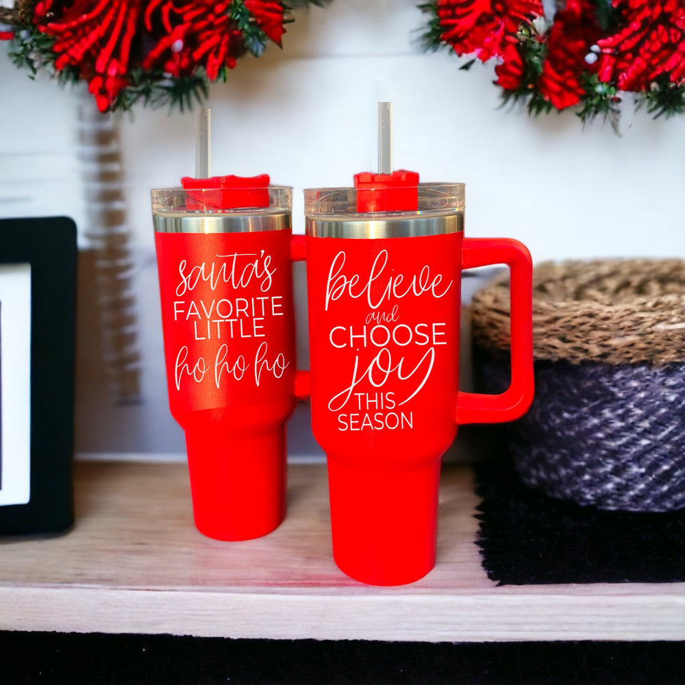 Believe + Joy 40oz insulated mug with a cheerful design and inspirational quote, featuring a lid, straw, and handle.