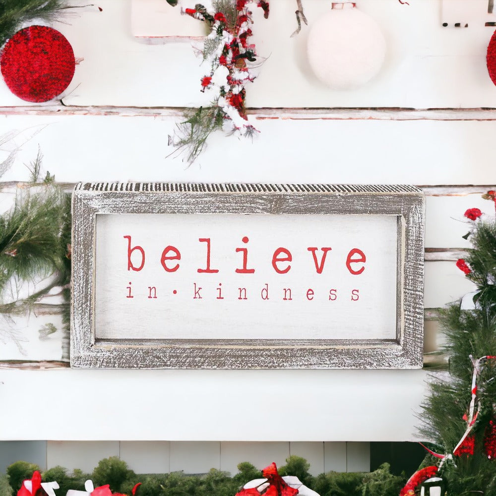 A wood framed Believe Sign featuring the phrase 'Believe In Kindness' in festive white and red colors, perfect for Christmas decor.